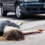 Injured woman lying in the road after being hit by a car in a pedestrian accident